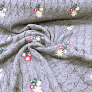 Zopfstrickstoff mit Blumenstickerei, eines franz. Modelabels
